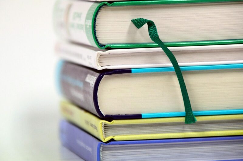 しおりをはさんで積み重ねた資格試験の参考書