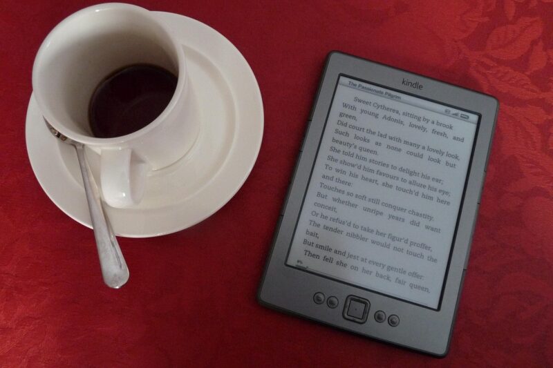コーヒーカップの横に置いた電子書籍リーダー